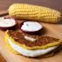 A closeup of cachapa with cheese and boiled corn on the background